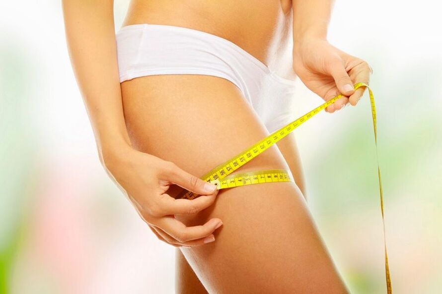 The girl measures her thigh volume
